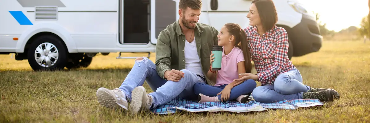 Mom, Dad, and daughter infront of an RV